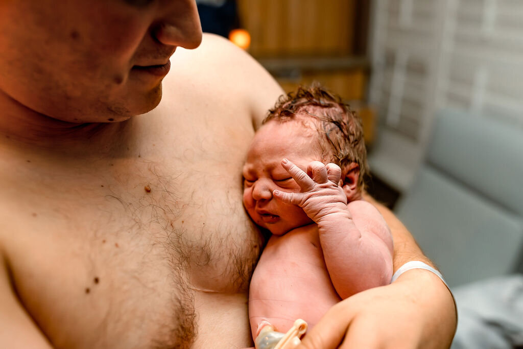 A father holds his baby, skin-to-skin, for the first time
