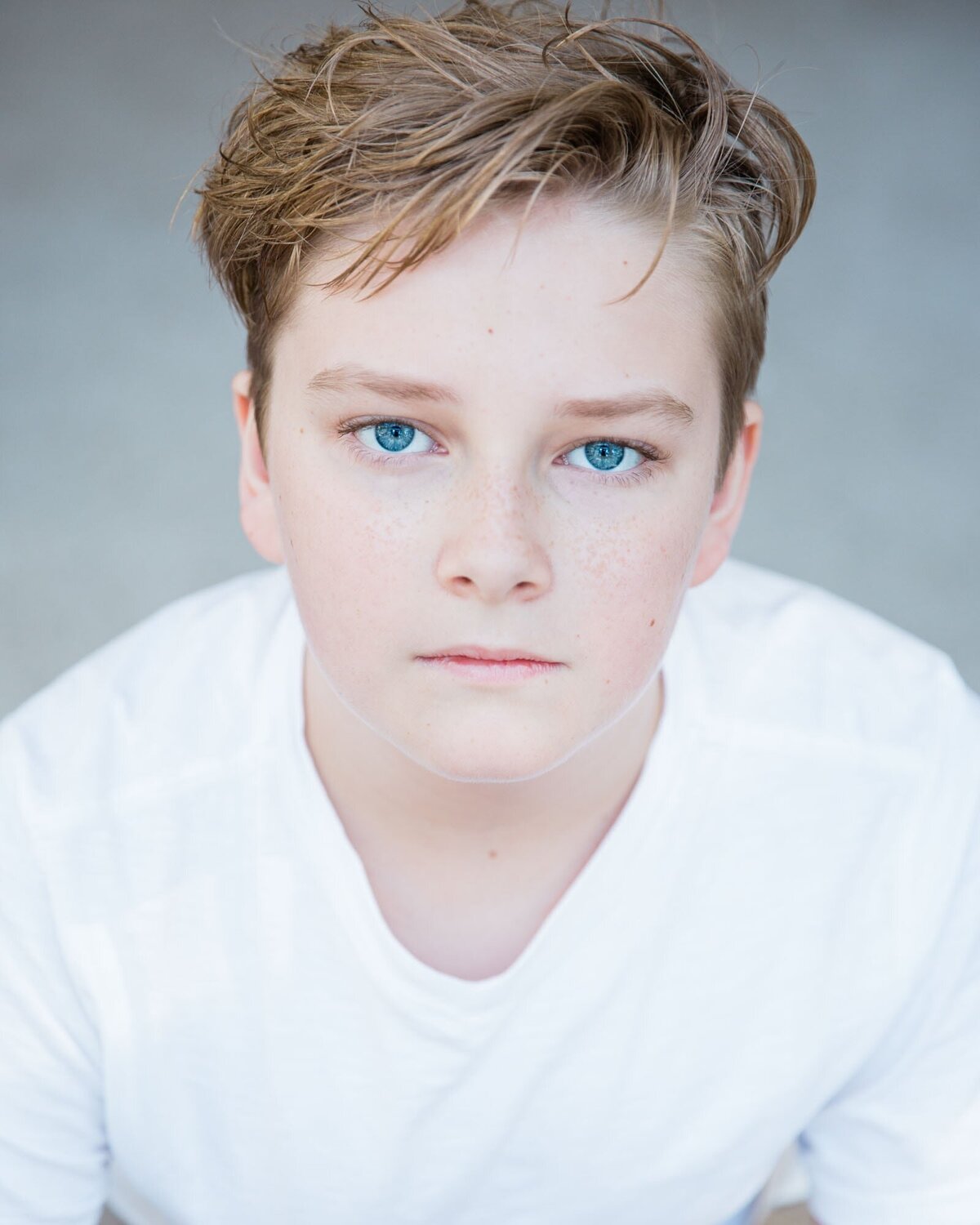 Headshot of boy with a white shirt and gorgeous blue eyes..