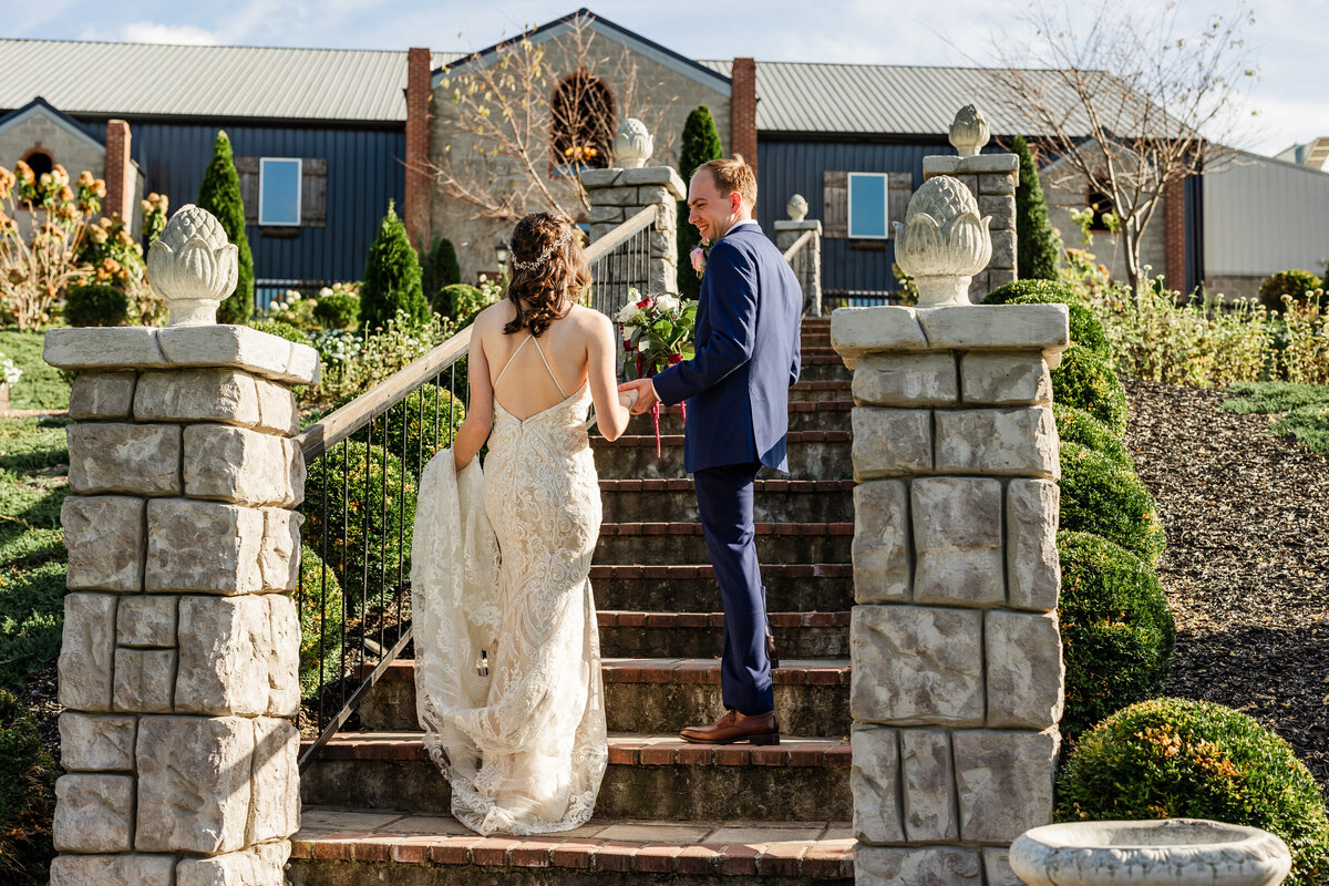 Groom leading his bride up the steps at Tayvin Gardens