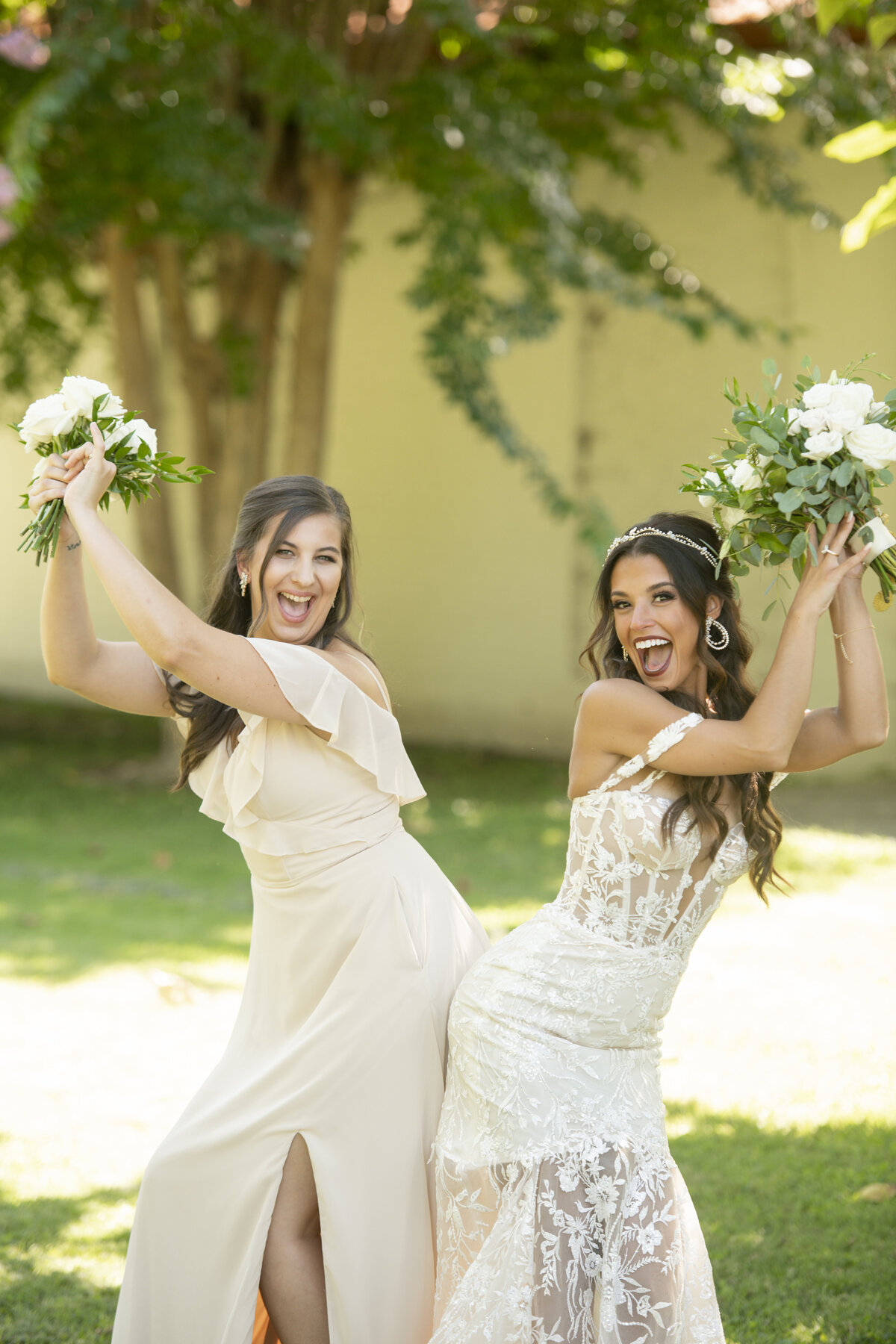 A radiant bride playfully tosses her bouquet, laughing under the sun at a dreamy outdoor wedding. A fun, candid moment coordinated by WINK! Weddings.