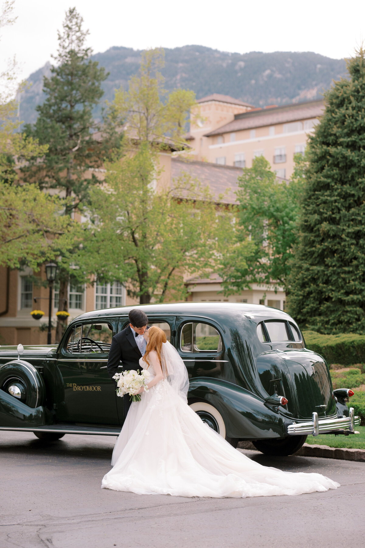 bride and groom with vintage car at The Broadmoor Resort in Colorado Springs, Colorado