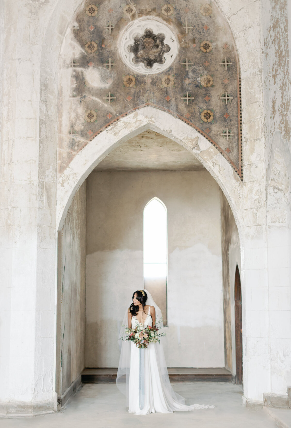 bride under ancient arches, historic wedding venue in Greece, Mediterranean film wedding photo