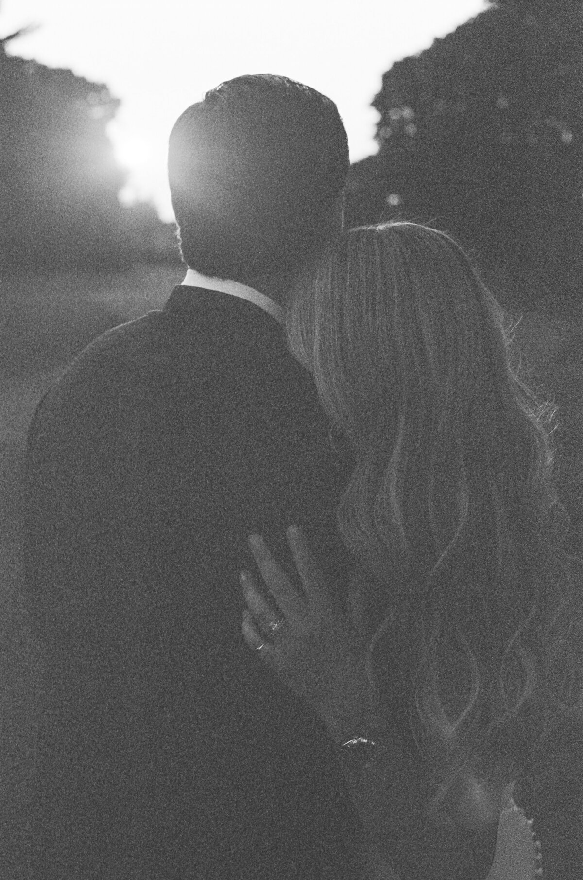 Black and white grainy film image of a couple at sunset.