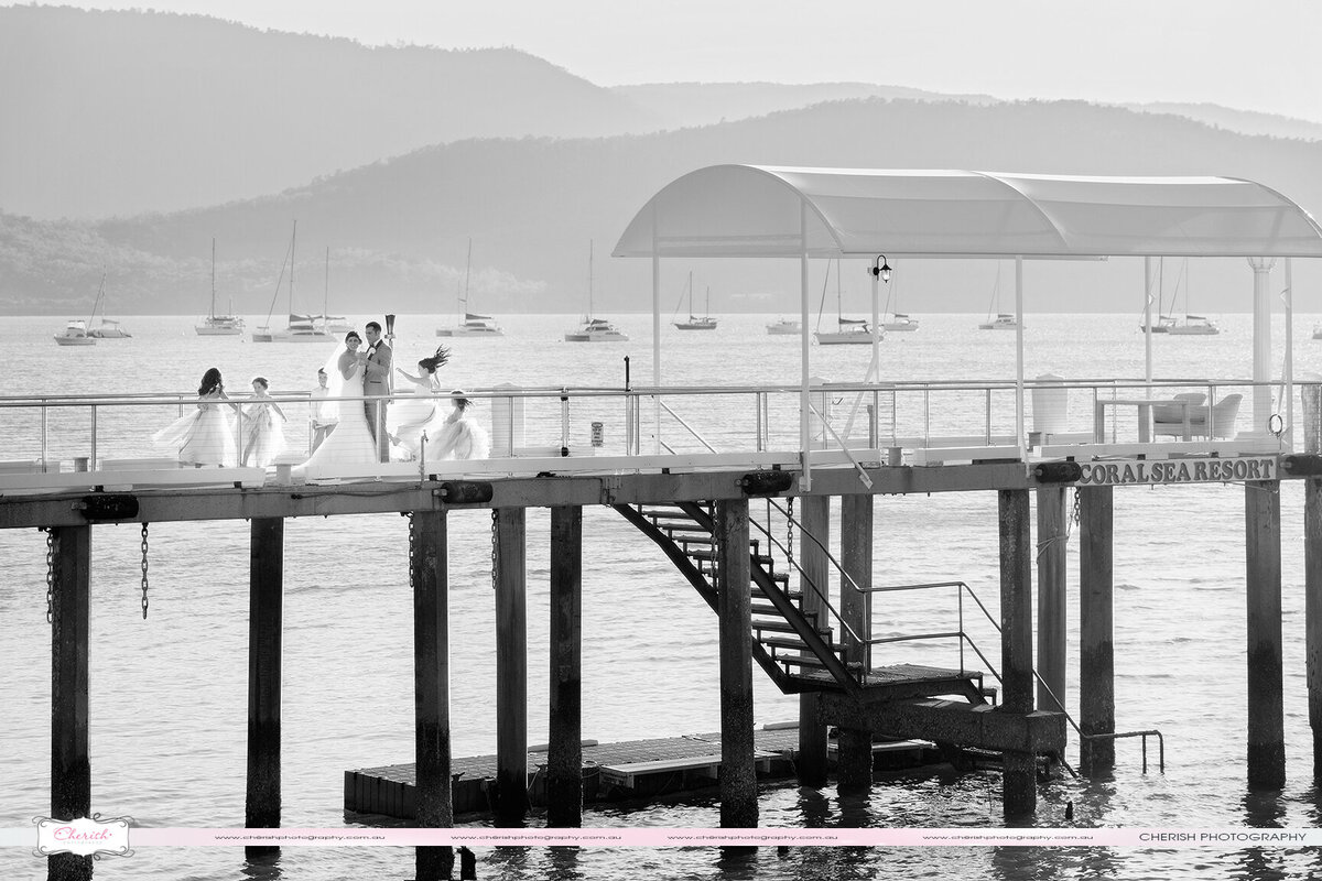 Bride and groom with children celebrate on Coral Sea Resort jetty in Airlie Beach.