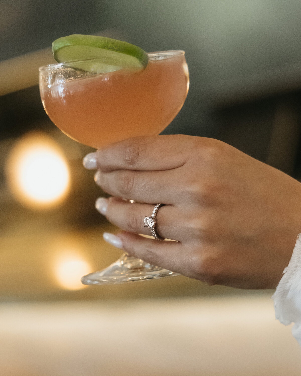 Bride to be holding her drink and showing her engagement ring