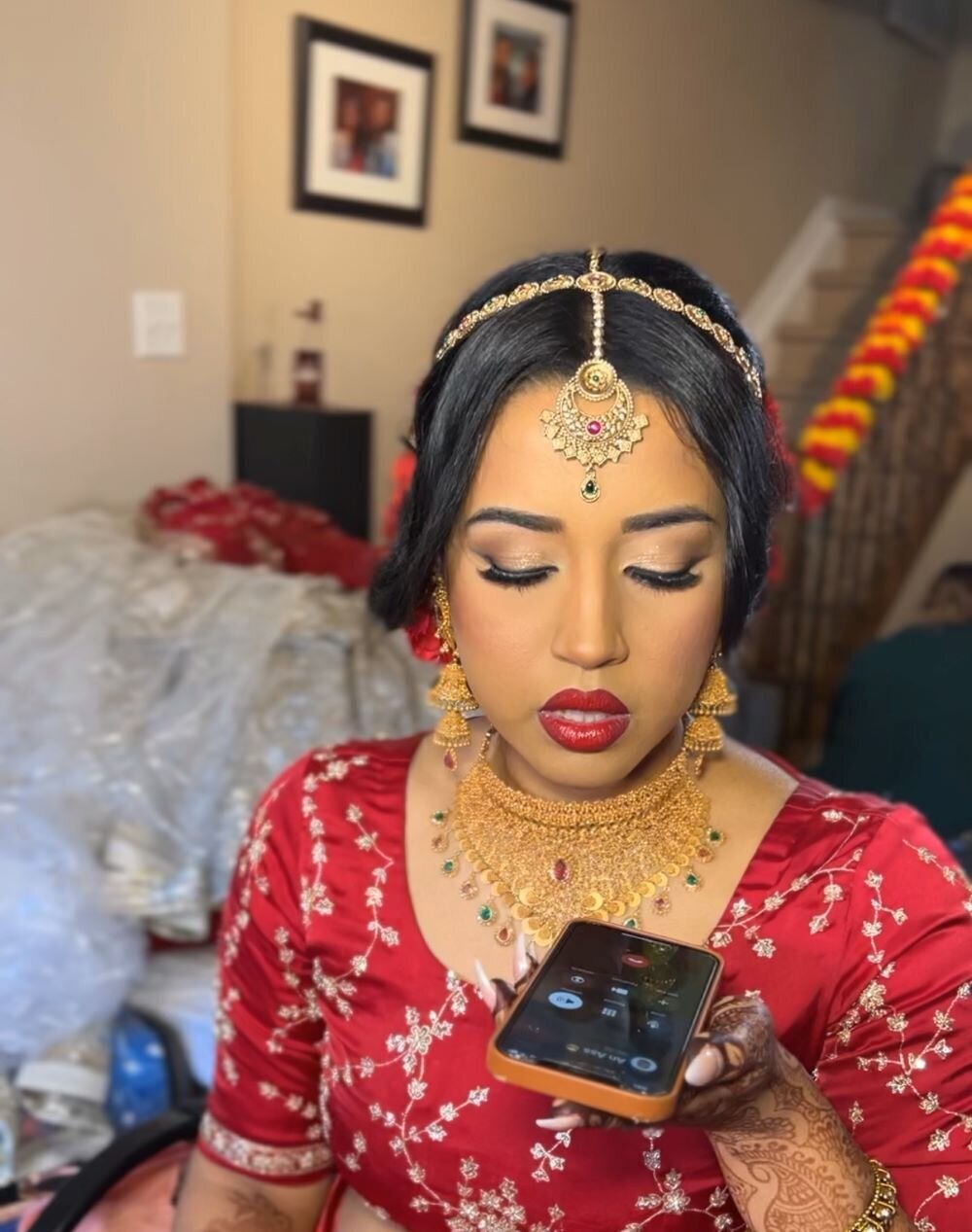 Ottawa Indian bridal makeup: Rich gold eyeshadow with intricate eyeliner and bold red lips for her wedding day.