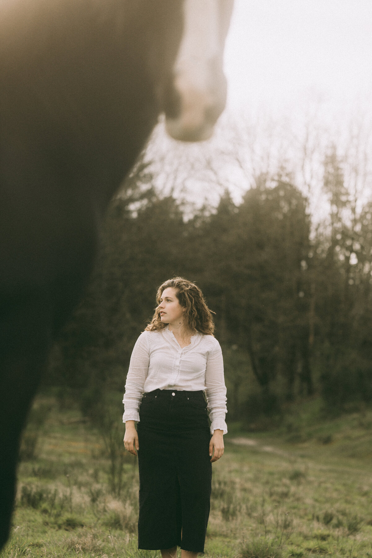 Verhalende paardenfotoshoot in de natuur, gefocust op spontane interactie tussen ruiter en paard.