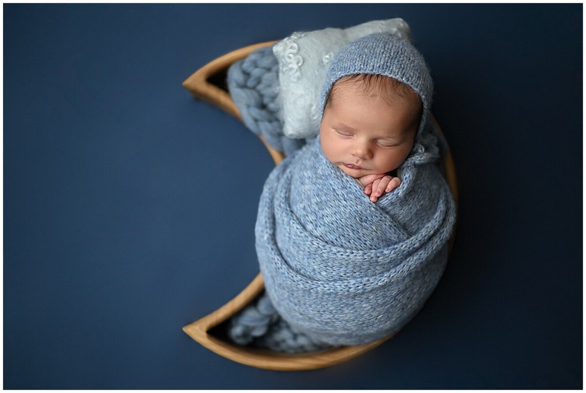 Newborn baby boy in moon bowl