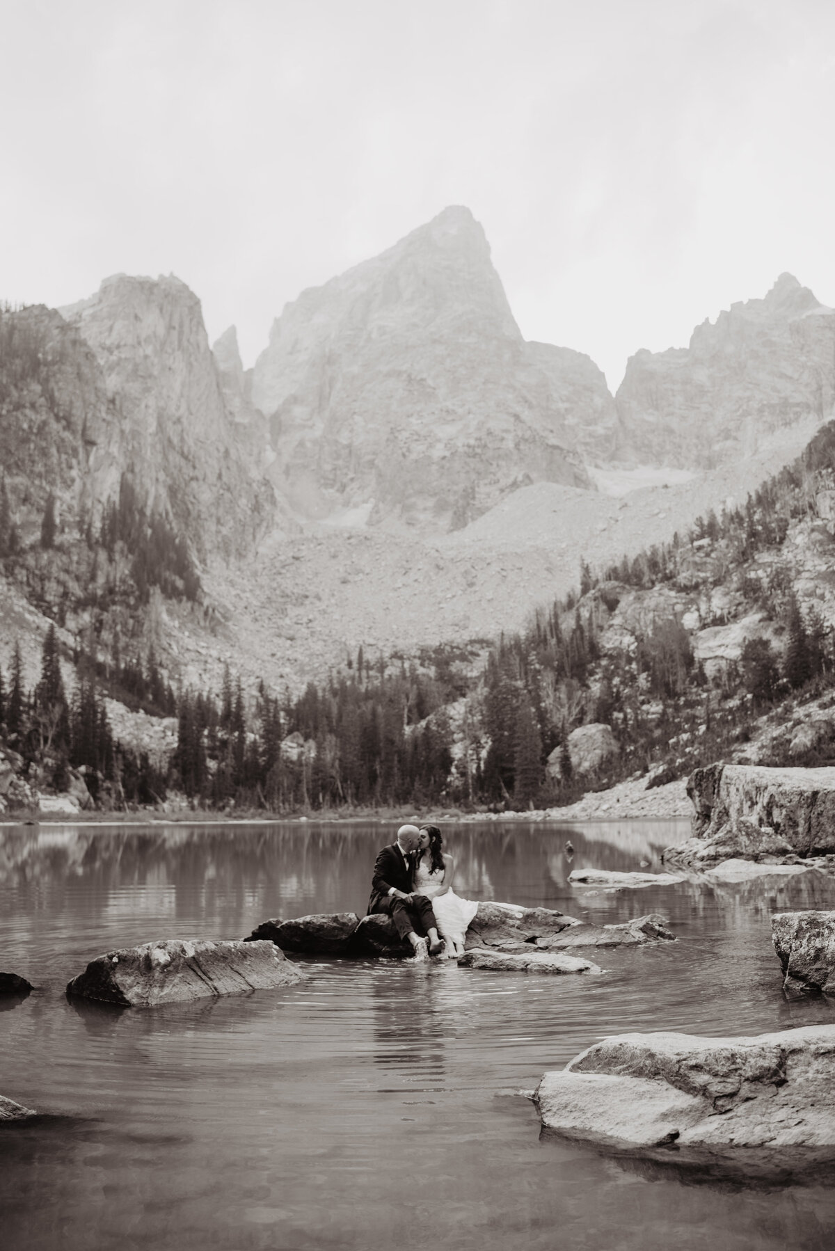 Jackson Hole Photographers capture bride kissing groom on rock