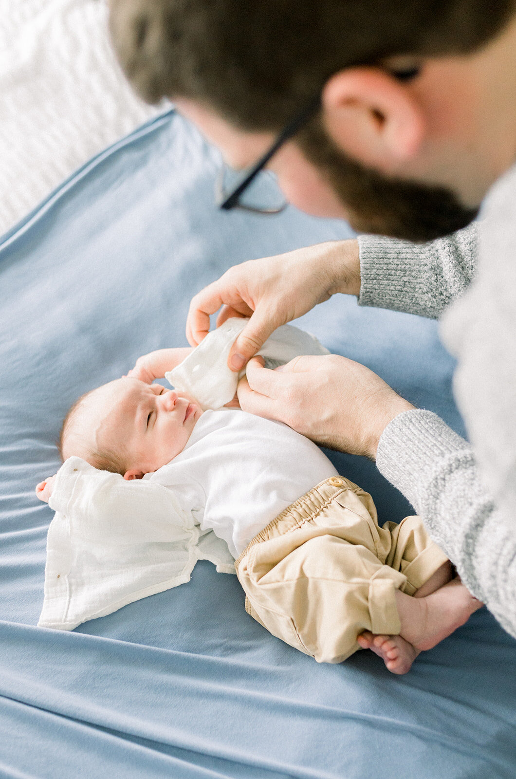 Dad leaning over a newborn baby as he stretches after a nap