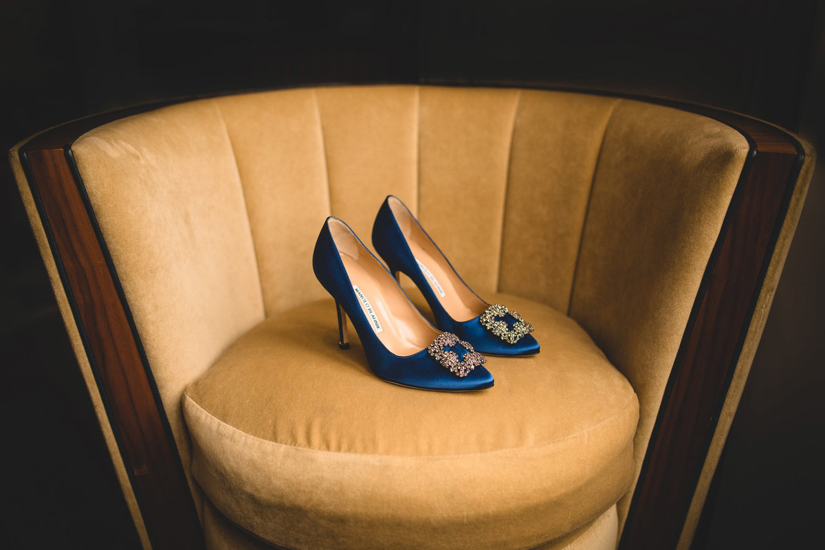 The brides Manolo Blahnik shoes are in a chair photographed in the Claridges bridal suite