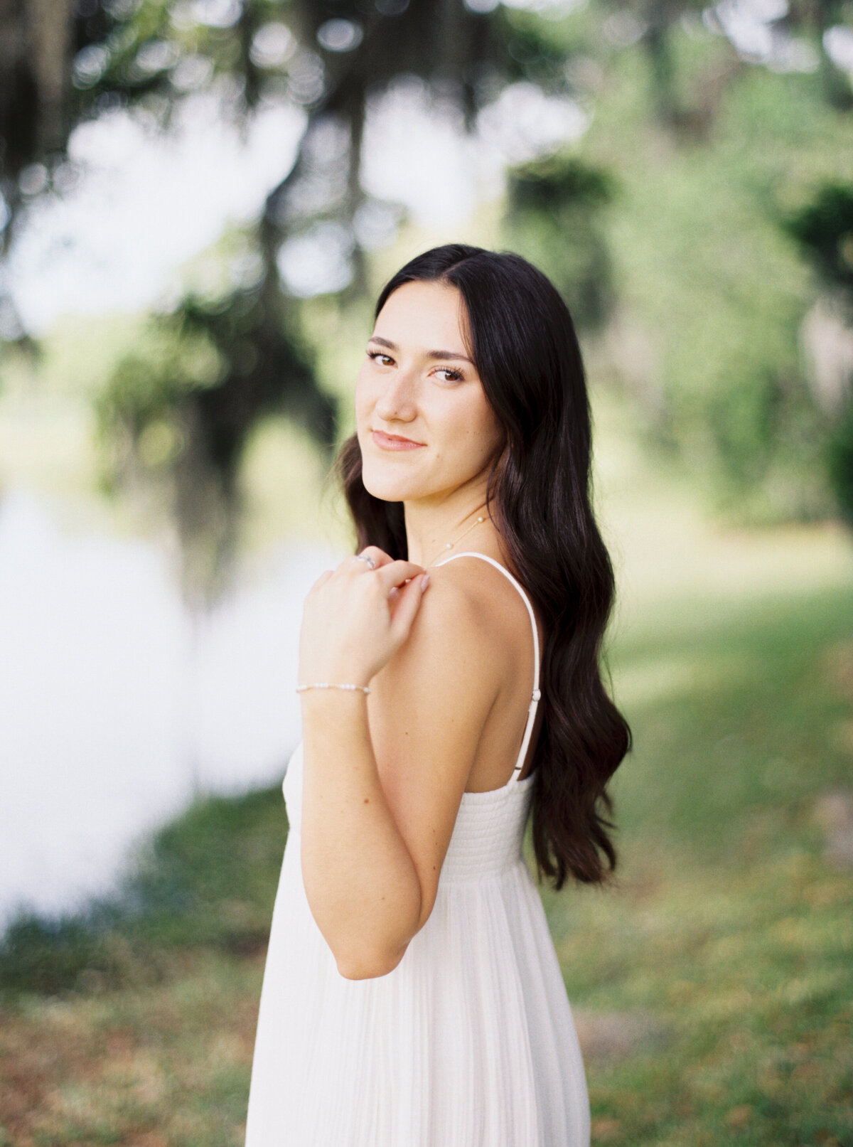 A serene senior portrait surrounded by blossoming flowers at Jungle Gardens, celebrating youth and elegance on film by Morgan Alysse, Louisiana film photographer.