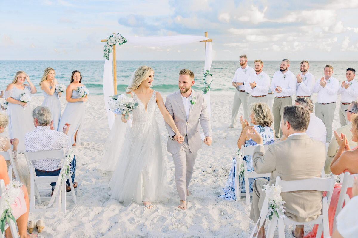 Bride and Groom walk down aisle celebrating after beach ceremony in Pensacola Beach, FL 
