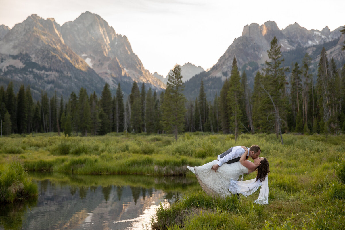 a groom dips his bride and kisses her after their Idaho elopement ceremony.