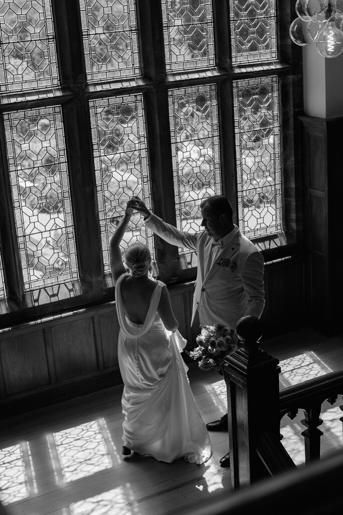 Black and white photo of newlyweds dancing inside Salt House surrounded by summer light and laughter
