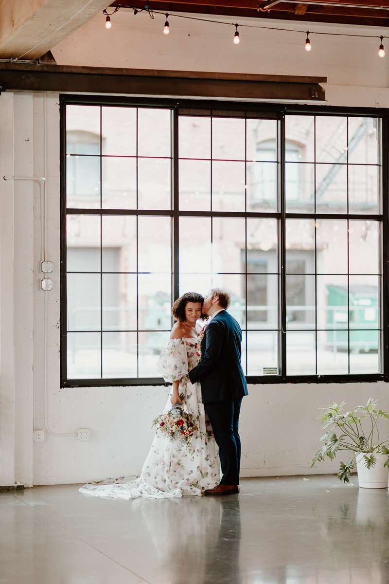 bride and groom in front of the large windows at castaway portland