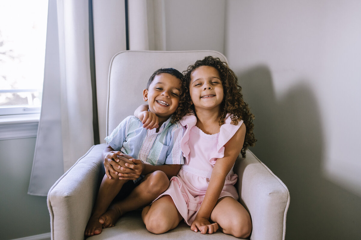 Siblings sitting in a chair at home, in Pittsburgh. 