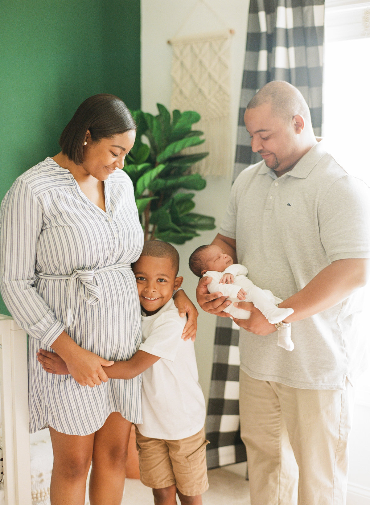 Family photo during a newborn session in Raleigh in an Emerald Green nursery. Photographed by newborn photographers Raleigh A.J. Dunlap Photography.