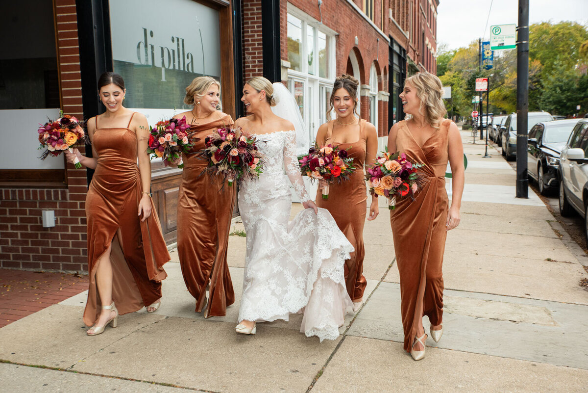 A bride and her bridesmaids are walking down the street