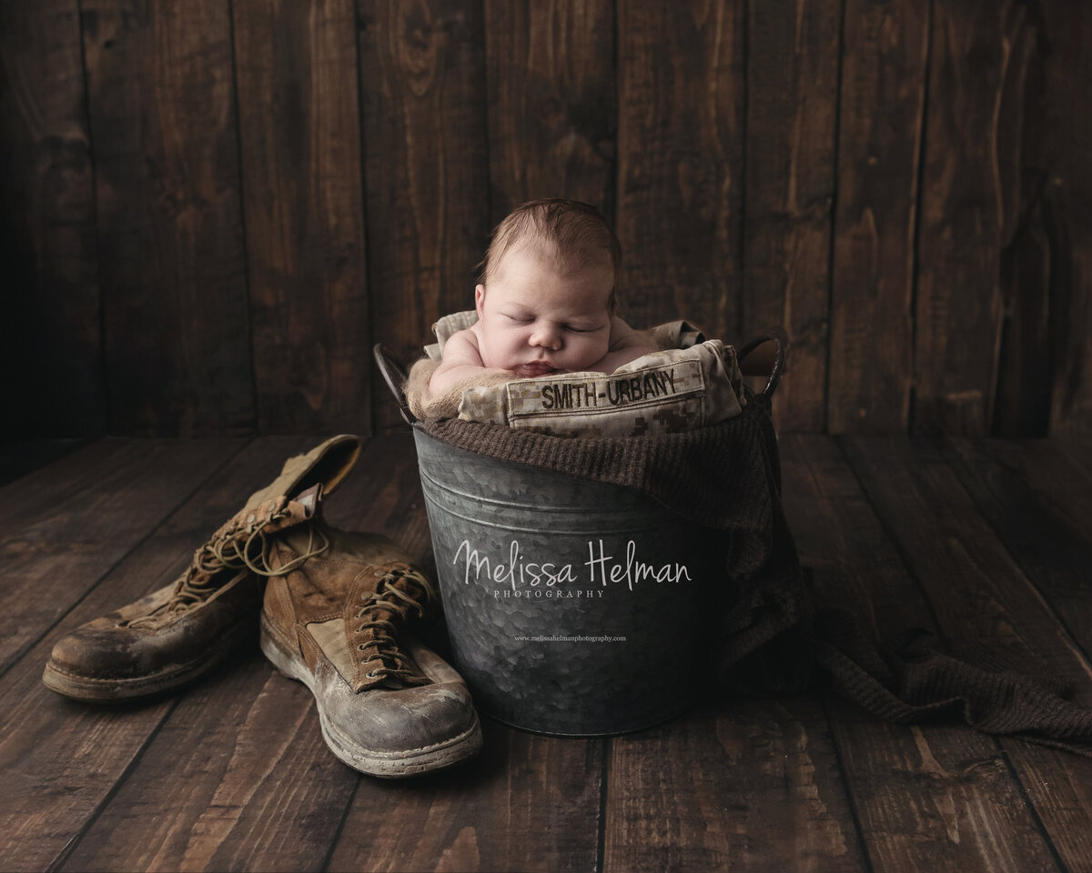 Baby boy sleeping in a bucket next to work boots in Greensburg studio.