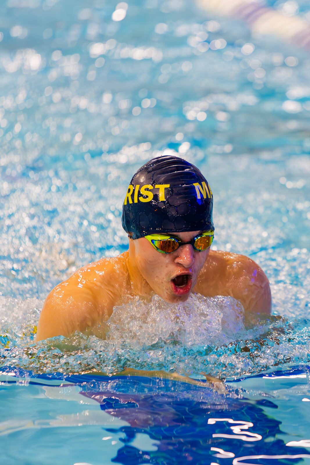 teenager swimming in indoor pool during a swim meet
