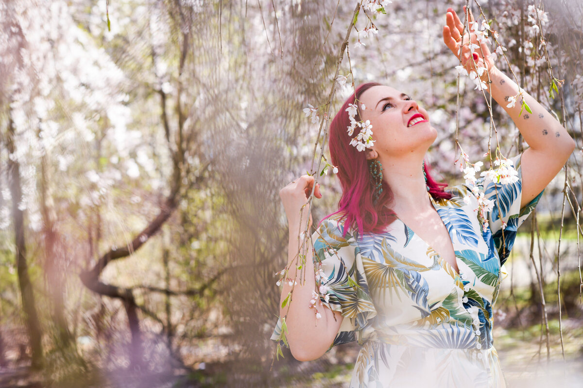 A person standing under a tree with vines hanging down around them