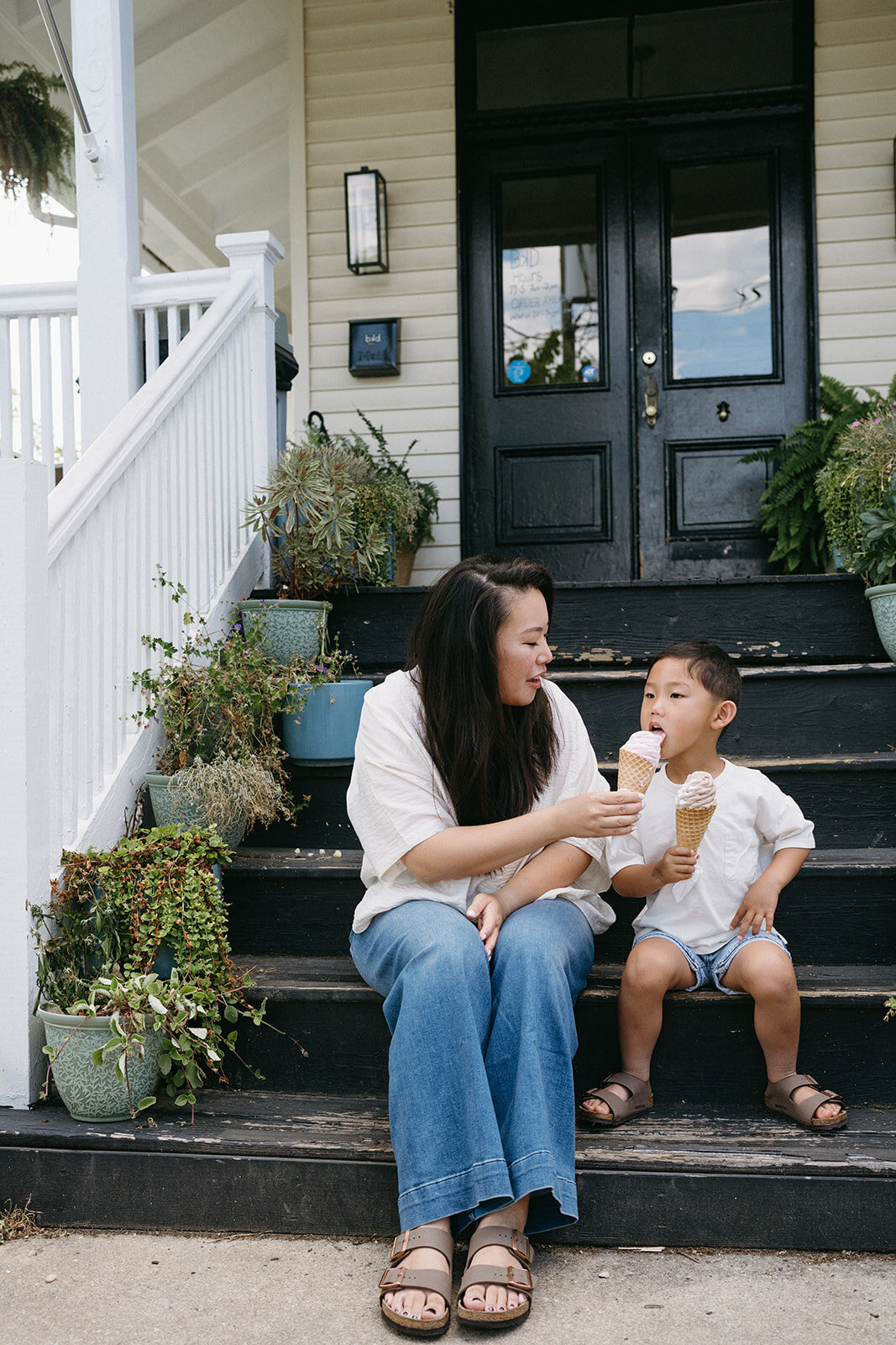 Mother and son smiling and enjoying ice cream during a lifestyle family session at a local shop

