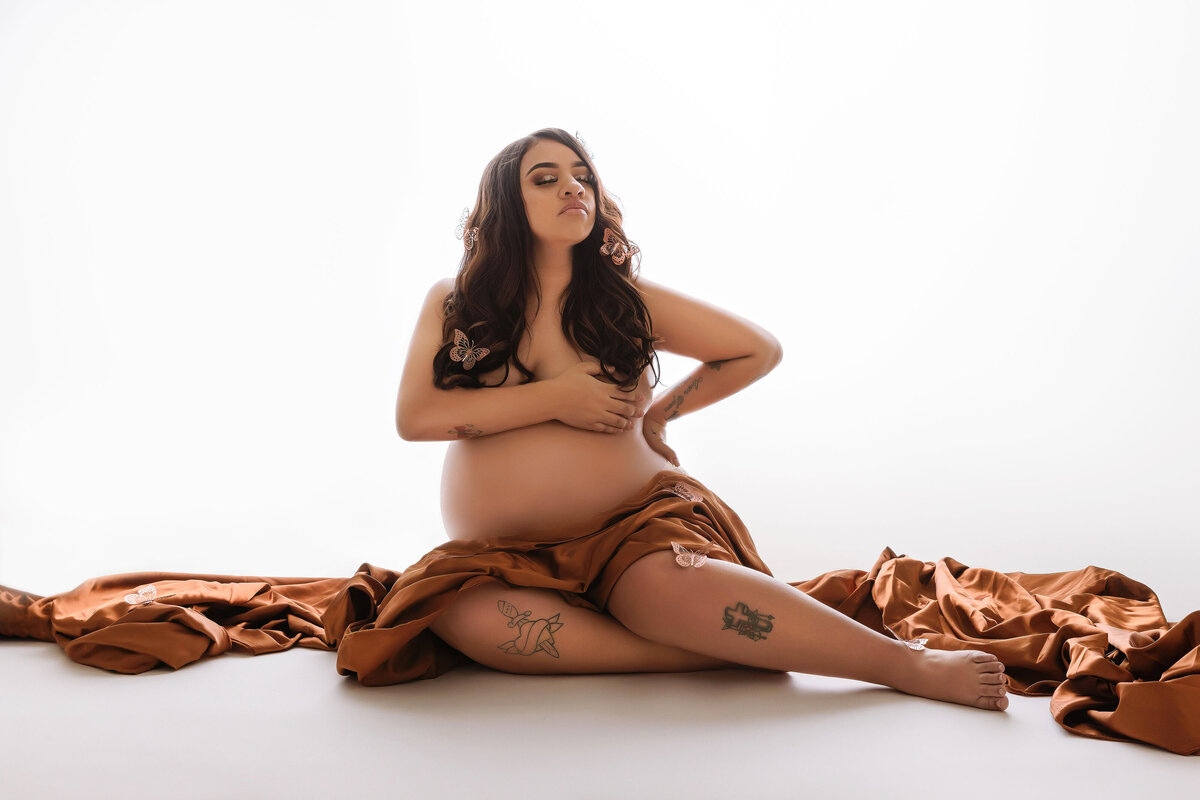 maternity mom posed on floor hold baby belly near bellevue
