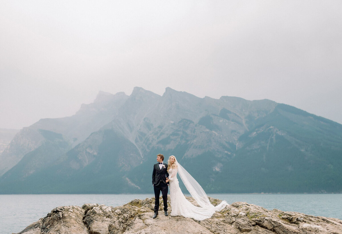 Bride and groom in Waterton, Alberta captured by by Kaity Body Photography, elegant film inspired wedding photographer in Calgary, Alberta. Featured on the Bronte Bride Vendor Guide.