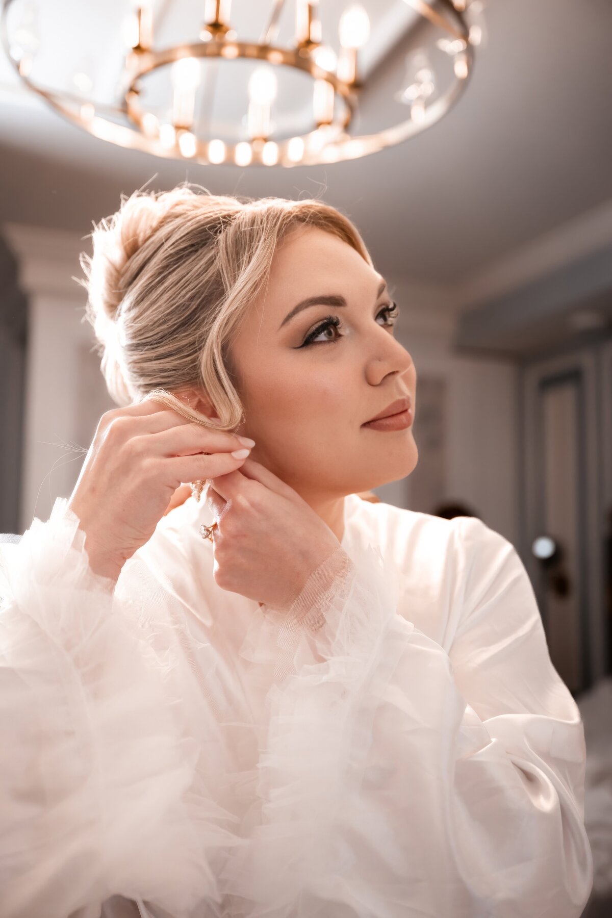 bride putting her earrings on