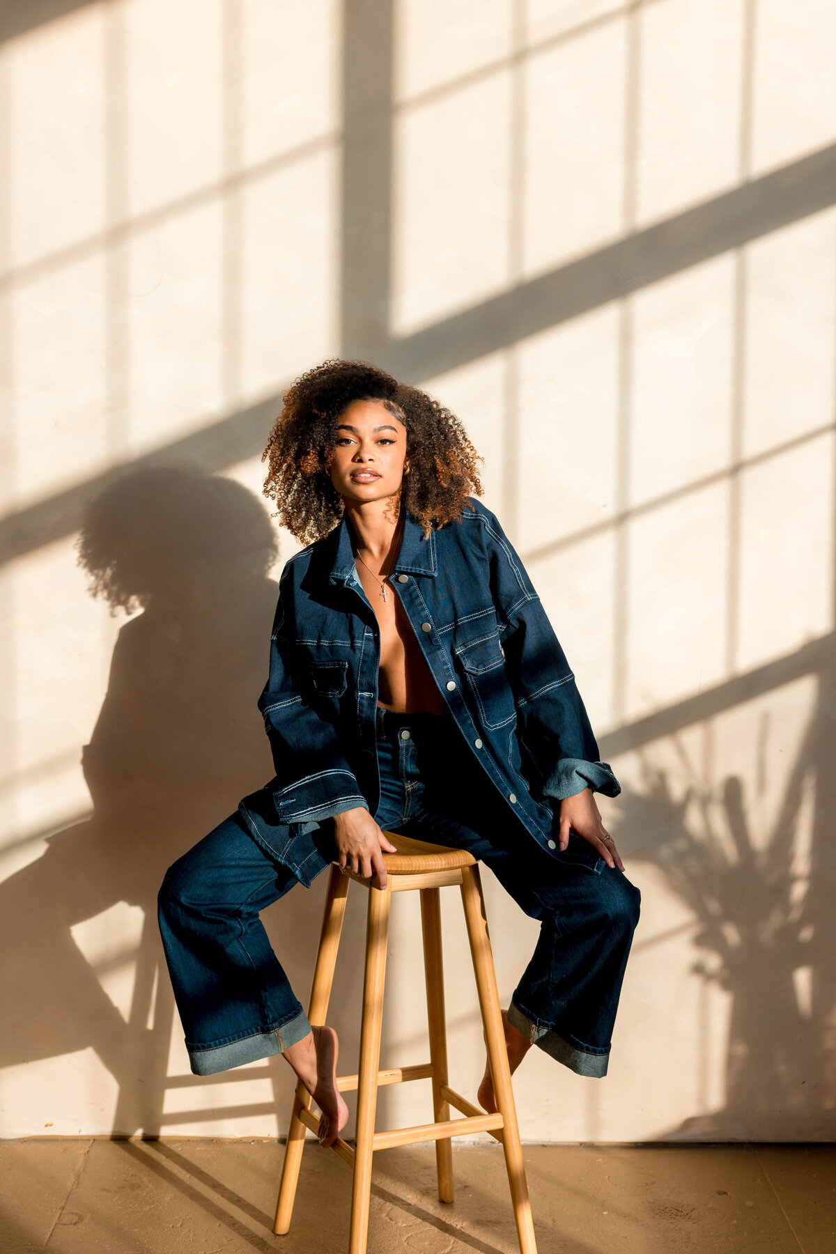 Black woman with all denim on in sunlit photography studio
