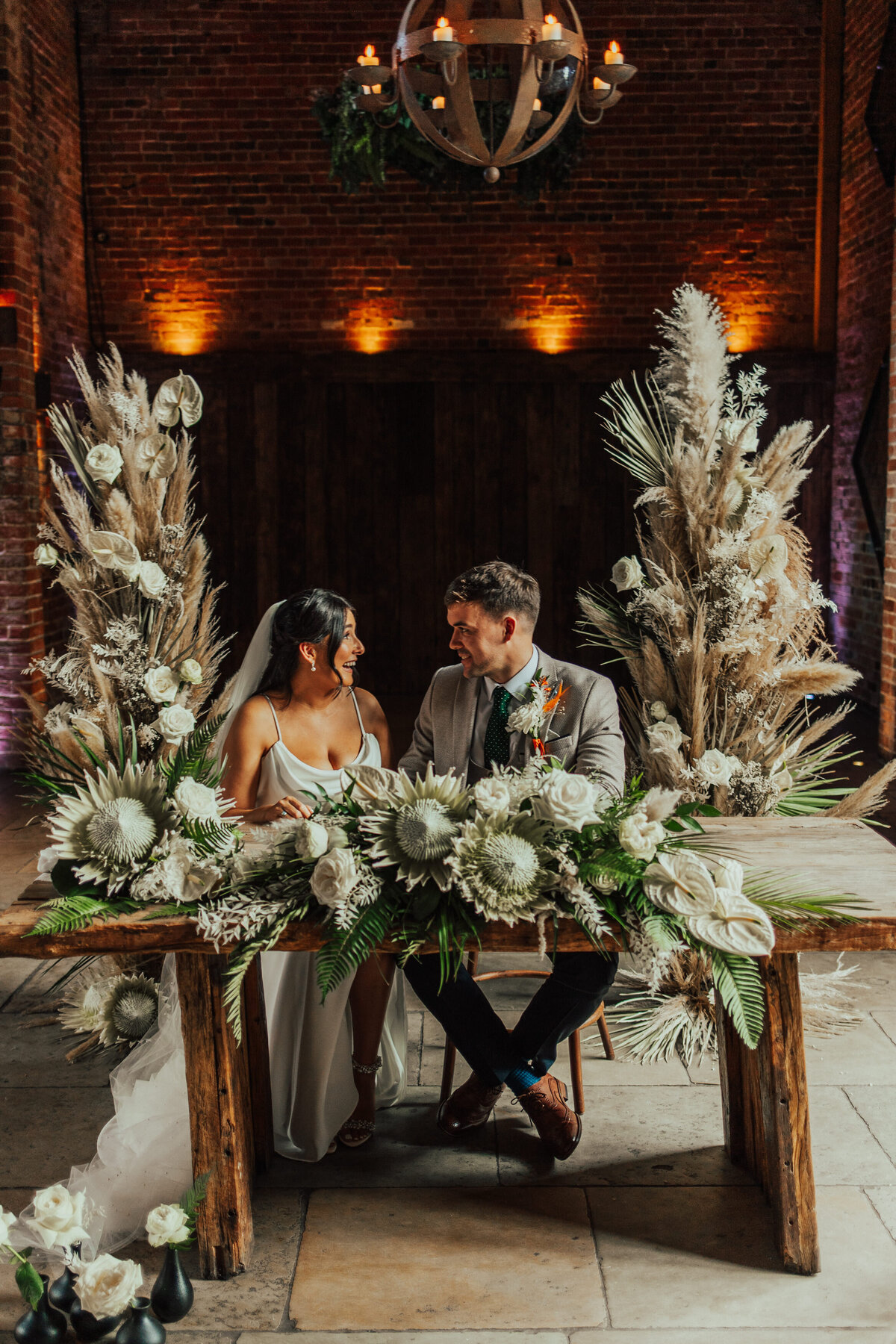 bride and groom with luxury florals featuring proteas