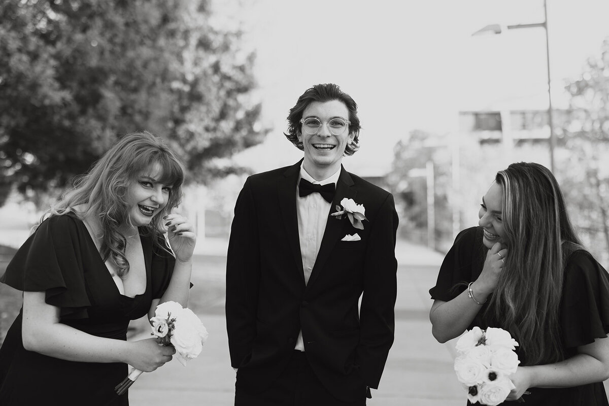 groom laughing with his sisters during wedding