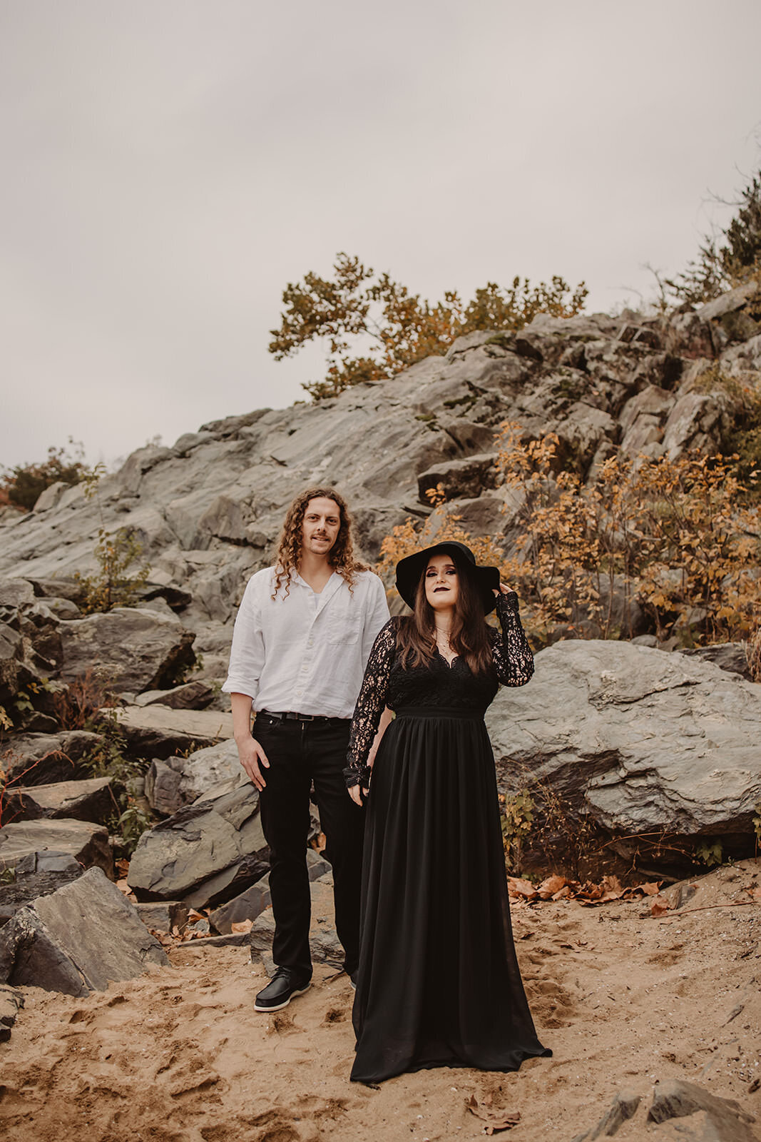 A couple standing together on a rocky hill 