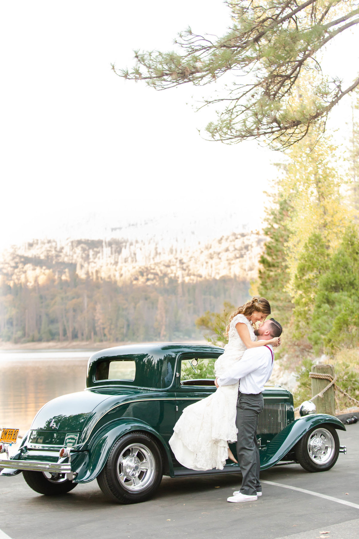 Bass Lake wedding couple kissing in front of vintage car