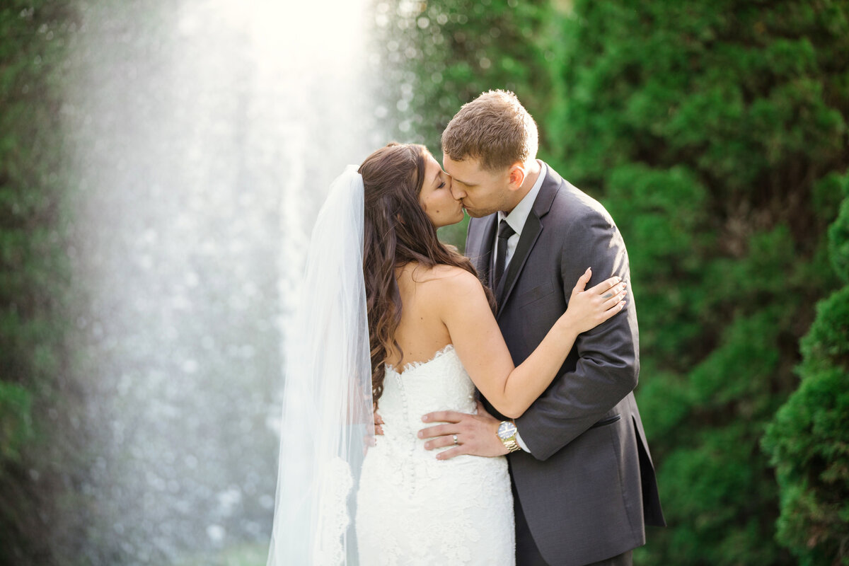 bride and groom kissing wedding photo under fountain at The Carltun