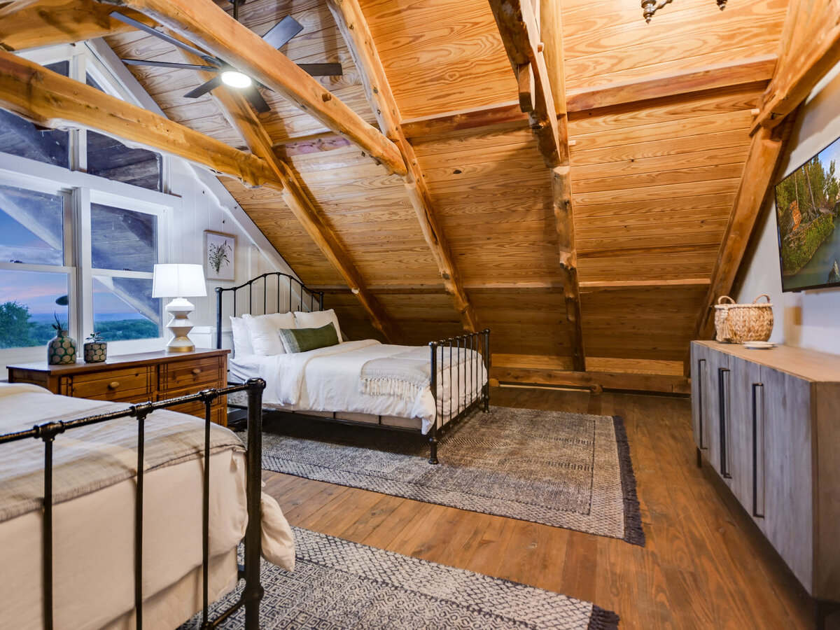 Loft bedroom with 2 beds and wooden ceilings