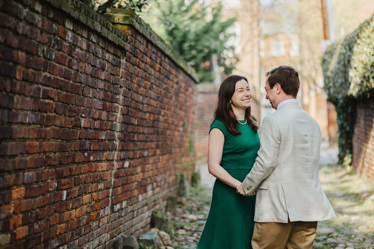 A couple smiles at one another in Old Town Alexandria.