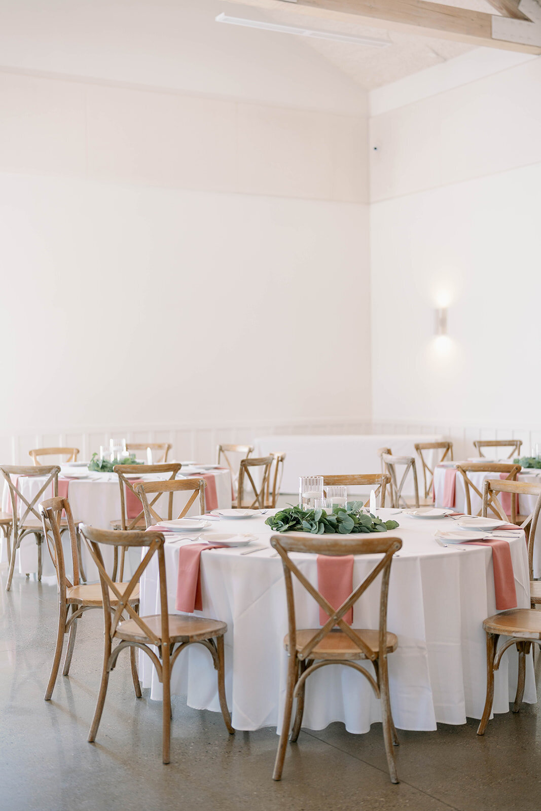 Reception room setup featuring soft pink linens and brown chairs at The Ivy House wedding venue.