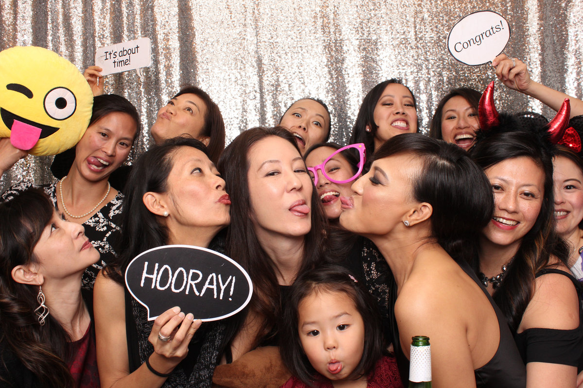 Group of ladies squeeze in together in a photo booth rental