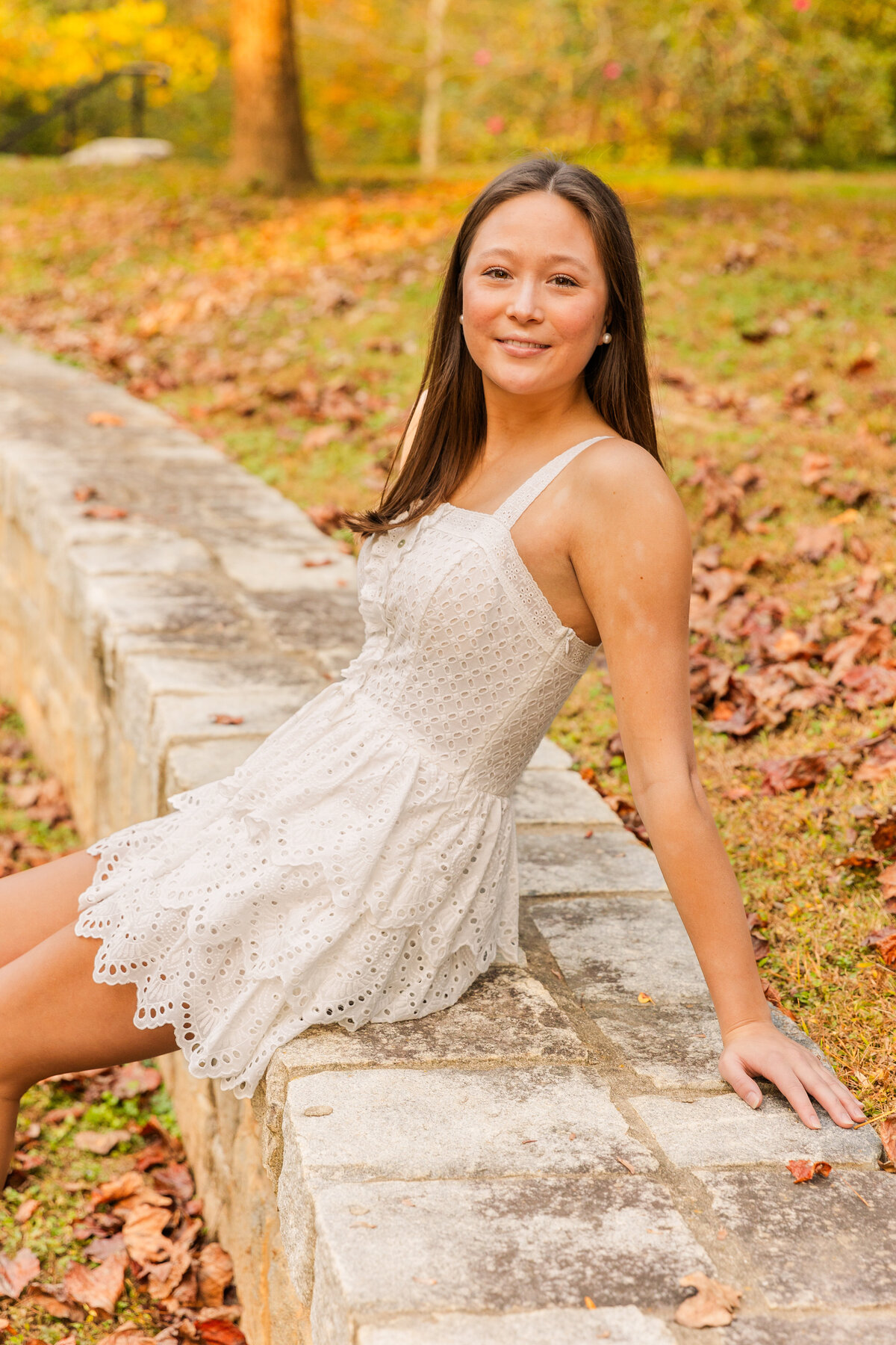 teenage girl in white dress sitting on a Atlanta Buckhead park wall