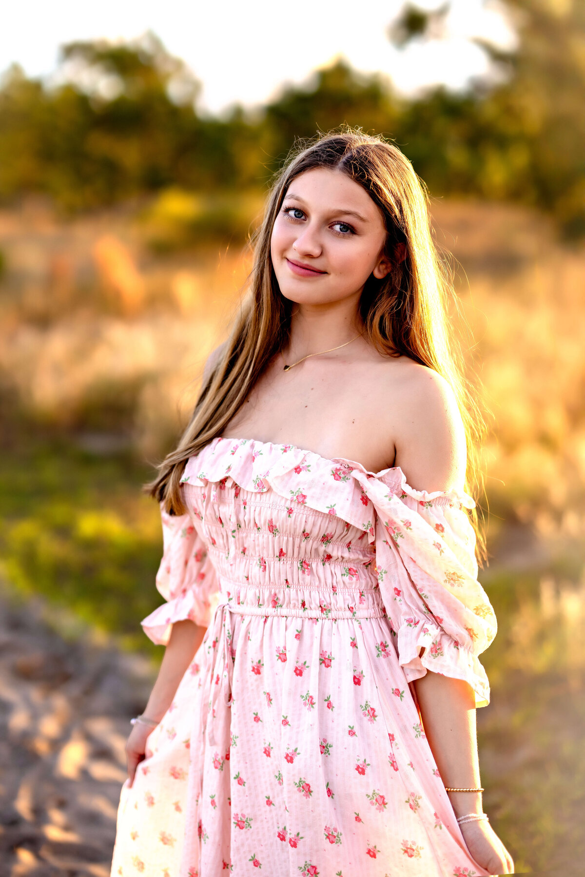 Orlando senior girl in a floral dress smiling in warm golden hour light