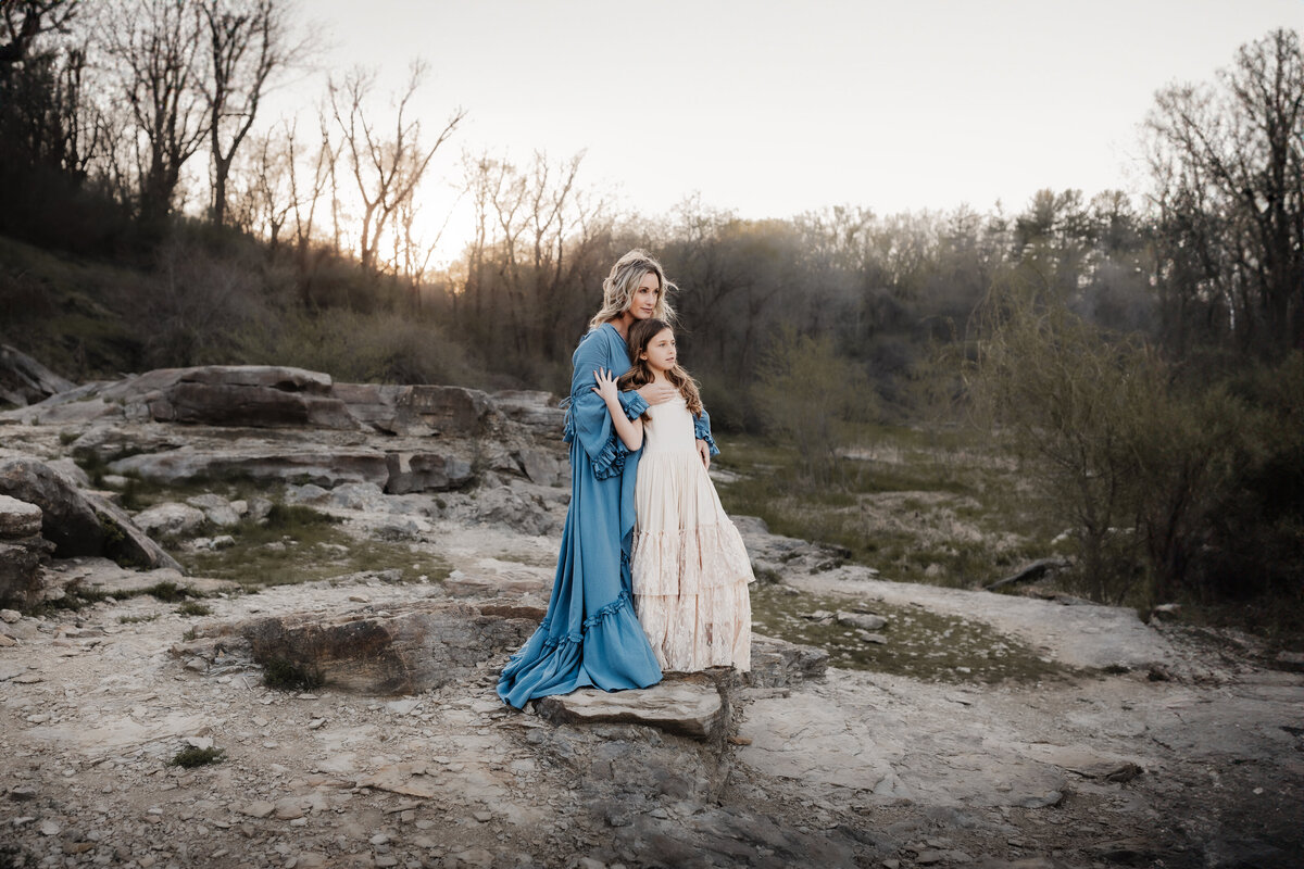 mother and daughter embracing on rocky gorge