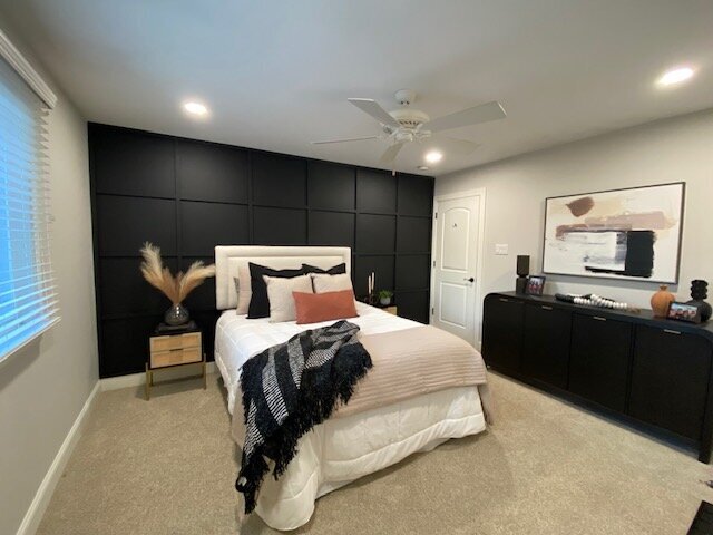 Bed against black wall with orange accents