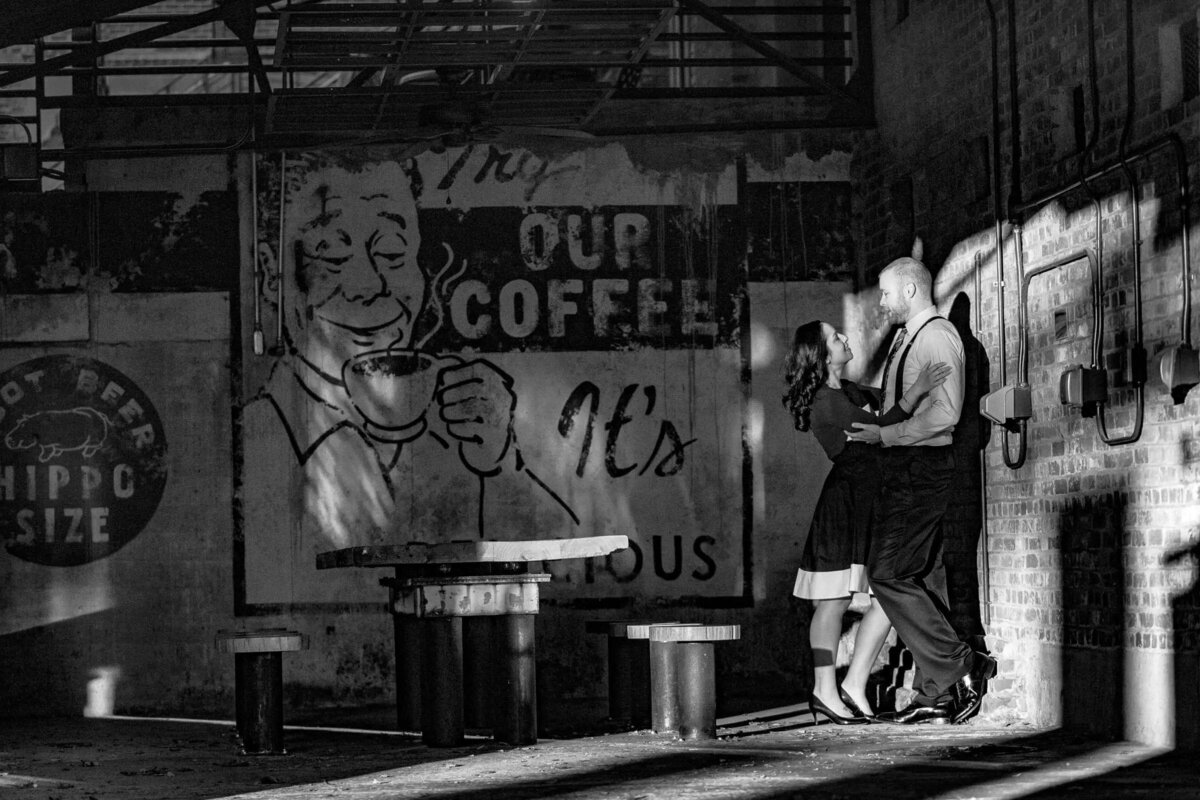 Monochrome image of a couple sharing a romantic moment in an urban setting, with graffiti art adding a vivid backdrop