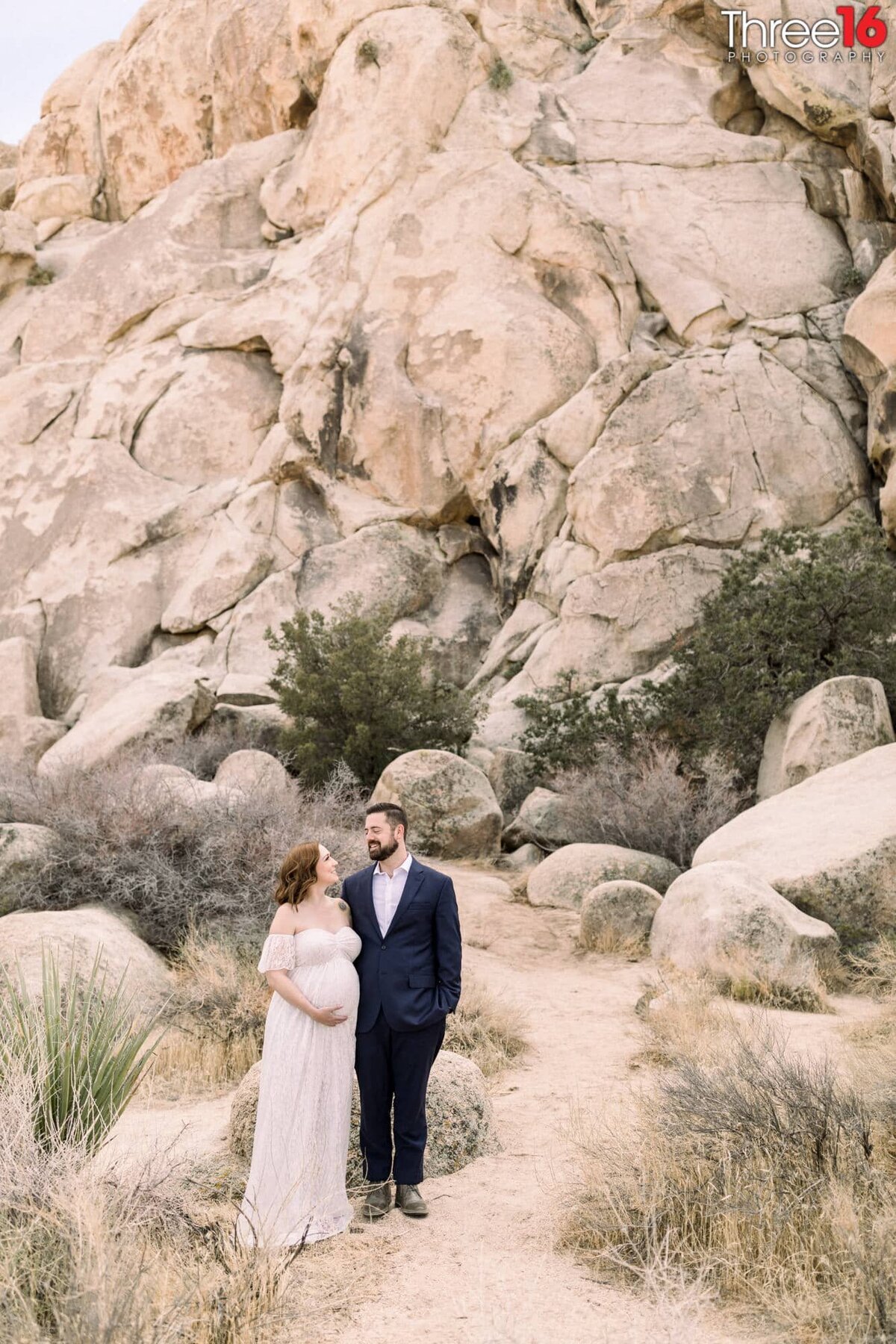 Soon to be parents look at each as they pose near the rocks in Joshua Tree National Park