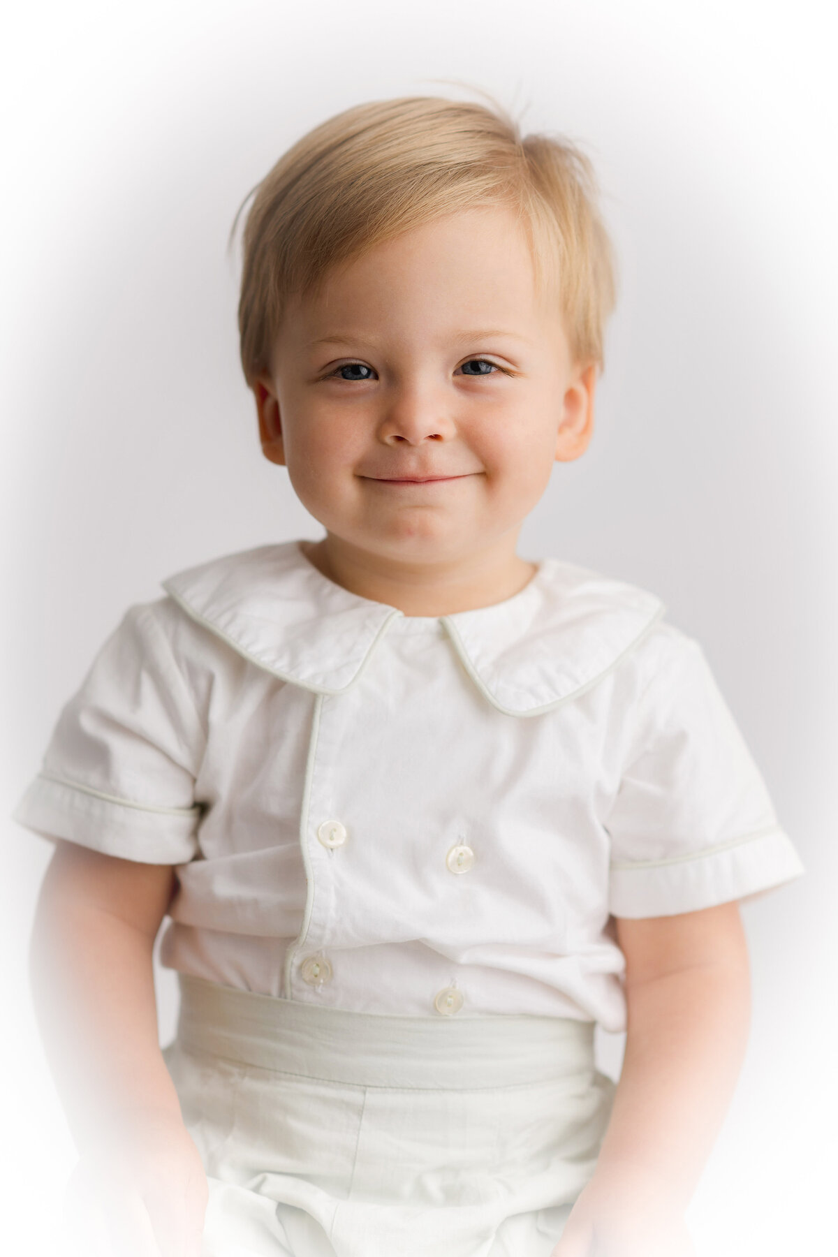 Baby boy grins at the camera during Heirloom Portrait Session in Charleston, SC photography studio.