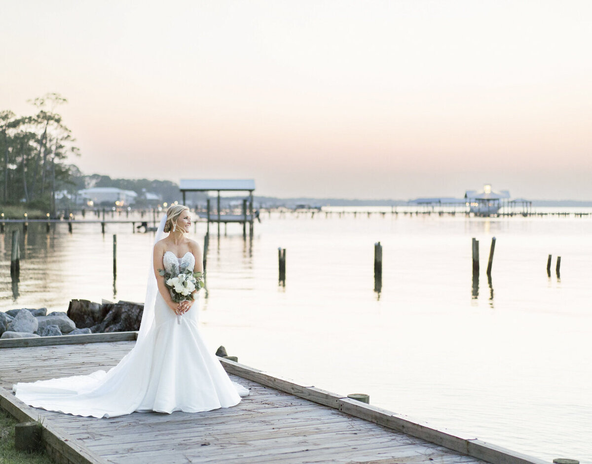 bride standing on a dock in a wedding dress