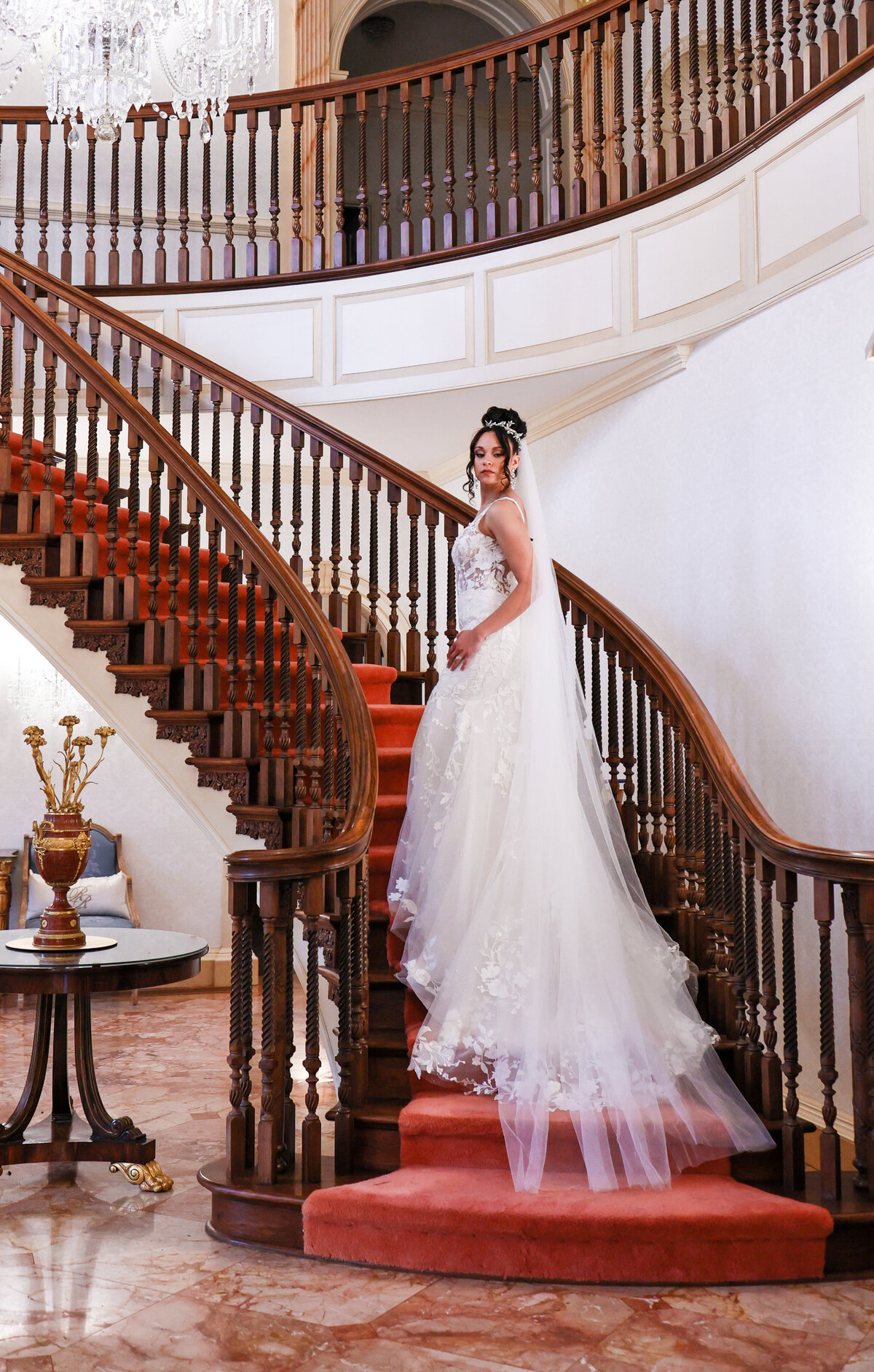 bride wearing a tulle and floral white dress with a  jeweled headpiece and a veil at Rust Manor House