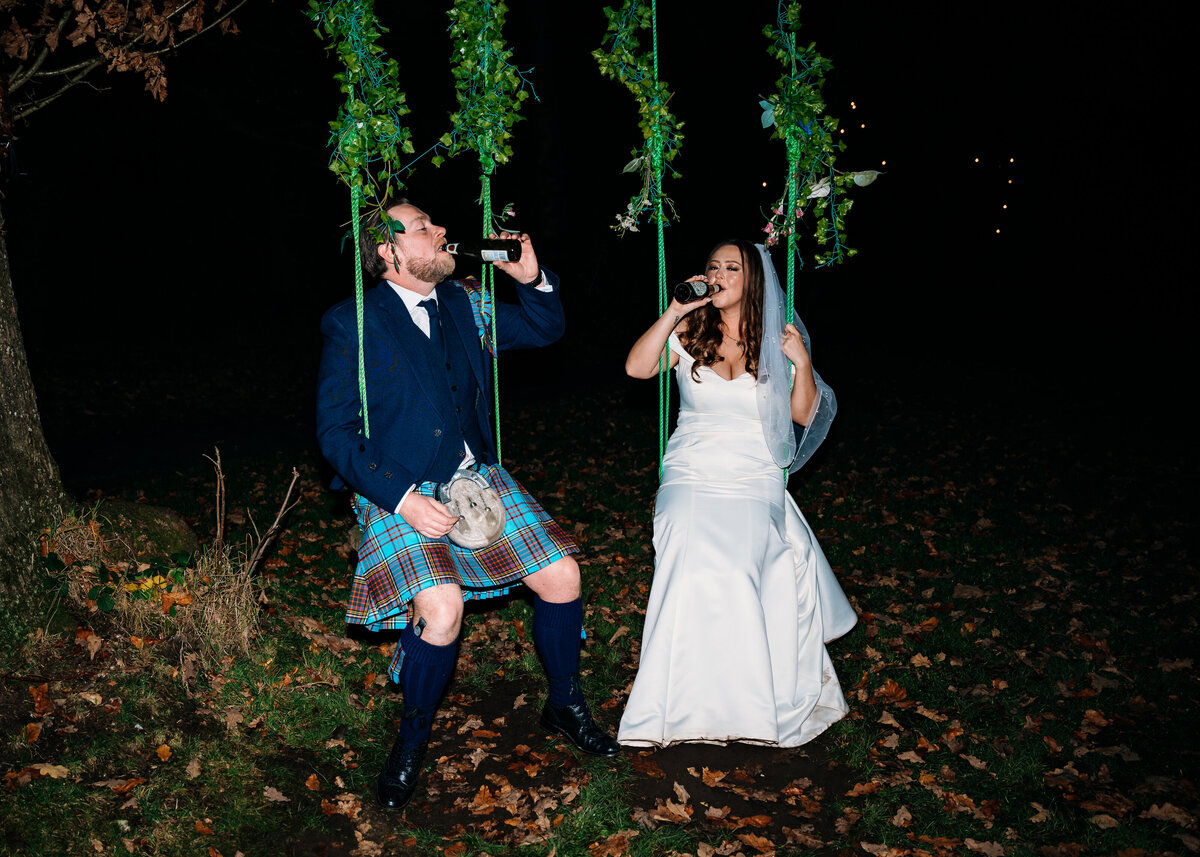 Bride and groom on swing drinking beer